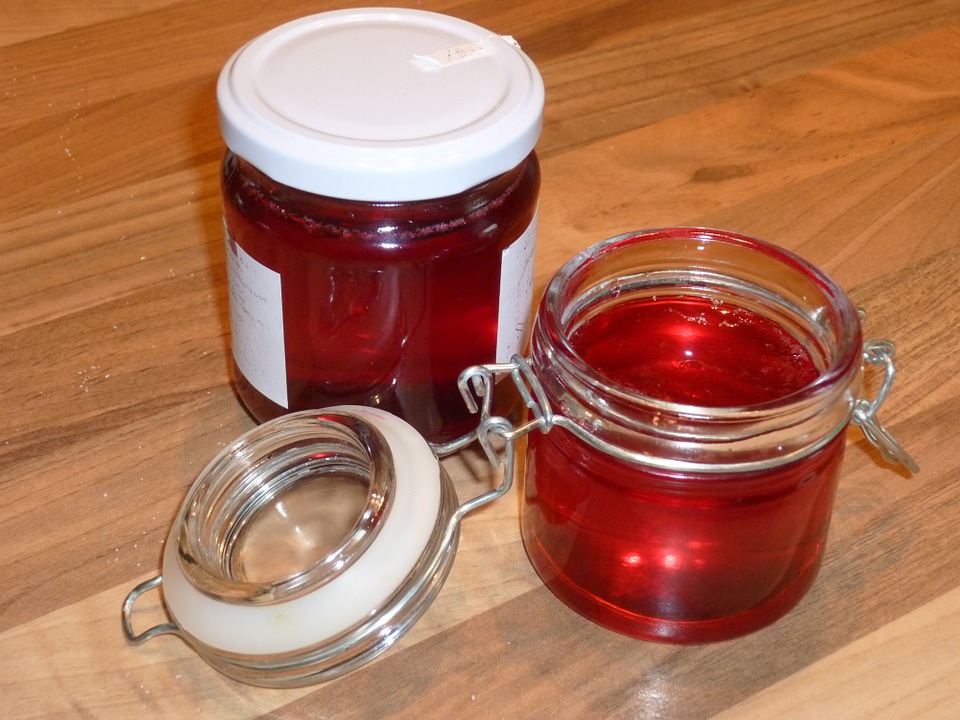 Two glass jars of red blackberry jam